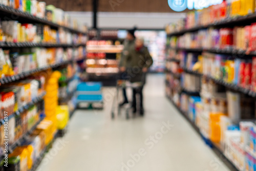 Photos Blurry image of shoppers in grocery store aisle with colorful products