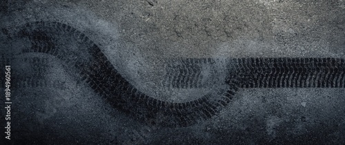 Top-down aerial perspective showing abstract texture and background with car tire drifts and skid marks on a road race track, black tire marks on street racing circuit, automotive theme