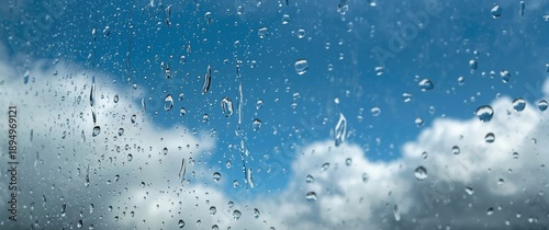 Blue sky visible through raindrops on a window