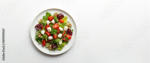 Colorful salad featuring a variety of vegetables like green and red leaves, positioned on a white background on an isolated plate, symbolizing healthy eating