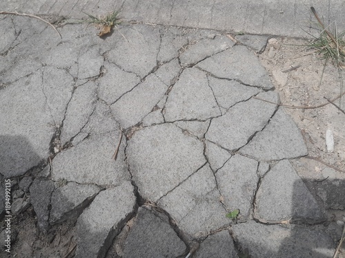 Severe cracks in the concrete pavement due to construction errors and lack of maintenance.