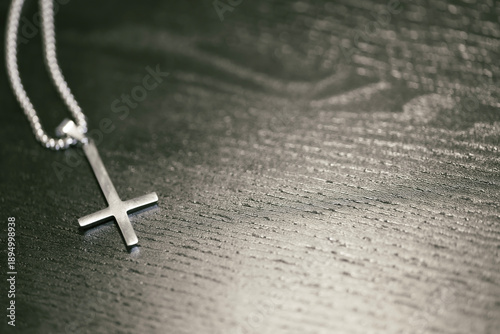 Foto Inverted Silver Cross Necklace on Black Wooden Background with Copy Space
