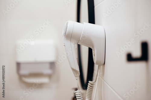 Tableau sur toile A white hairdryer is hanging on the wall in the bathroom