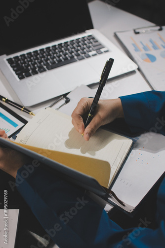 Businesswomen analyzing financial data, discussing investment strategy in office