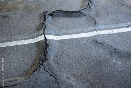 фотографія asphalt surface broken by root heave