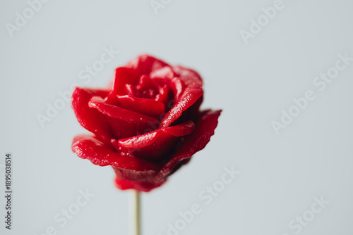 Photos Red lollipop in the form of rose flowers closeup on white background