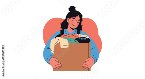 Caring young woman smiles while holding a large cardboard box filled with folded clothes for a donation or moving project.