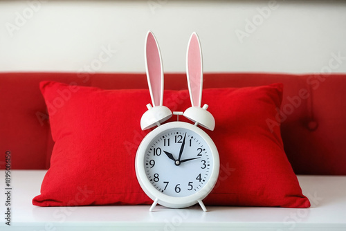 Reloj clásico junto a cojín rojo simbolizando insomnio, paso del tiempo y problemas acumulados. Concepto visual sobre noches largas, cansancio emocional y la dificultad de desconectar la mente