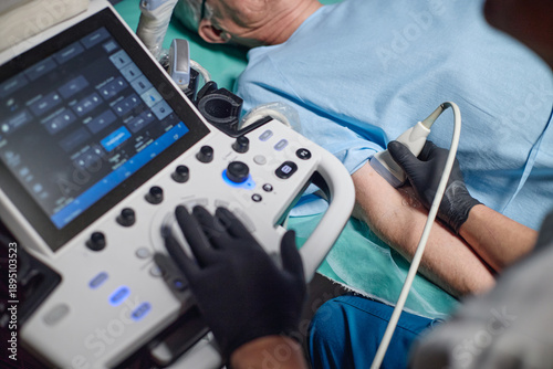 Tableau sur toile Senior Caucasian man lying on examination table receiving vascular ultrasound on