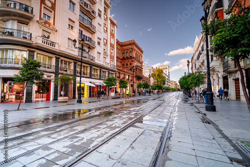 Main Street in Seville with colorful houses and people, life on the streets of the Spanish city, Andalusia.