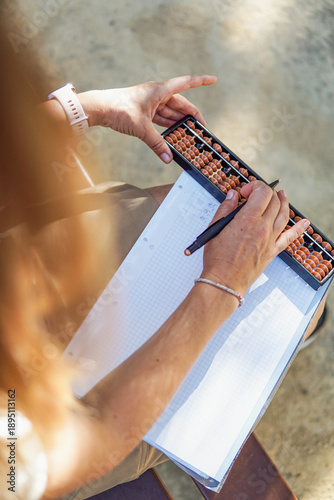 Mental arithmetic teacher practicing Abacus system outdoors, learning mathematics with abacus