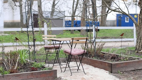 Сhairs and table at outdoor or outside for relax. Backyard with garden furniture set and garden bed for greenery. Interior cozy patio with arch at home.	
