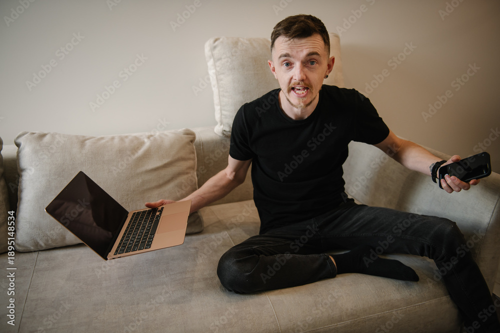 Fototapeta premium Young busy stressed business trader, analyst man reading bad new on the financial market. Male feeling angry working in home office. Investor broker analyzing indexes, trading online investment data.