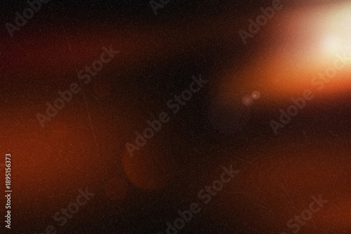 Warm light lens flare on a dark dusty background creating a mysterious glow effect