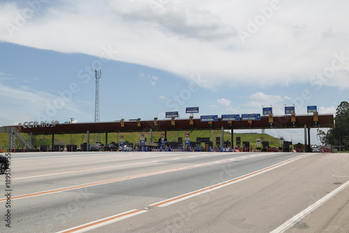 Praça de pedágio em rodovia movimentada, simbolizando mobilidade, transporte, logística e conexão entre cidades. Conceito de tráfego, infraestrutura moderna, viagens, deslocamento e fluxo econômico.