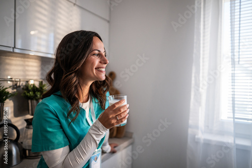 Photos Nurse in kitchen enjoying healthy milk for wellbeing