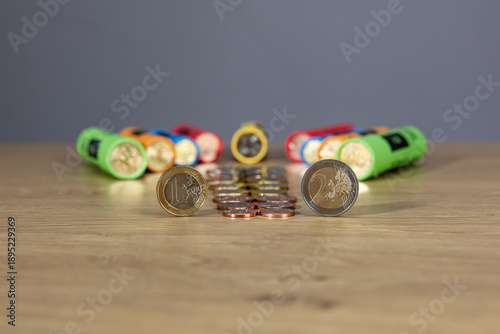 New collection of Bulgarian euro cents photographed on a wooden table. Colorful vertical columns with coins in denominations: 5, 10, 20, 50 cents and 1 euro. Selective focus and close-up.