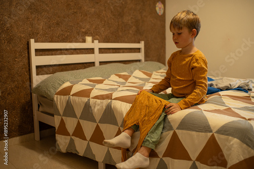 Wallpaper Mural Little boy preparing his pajamas on the bed before sleep, cozy bedtime routine at home. Childhood, evening ritual, comfort and calm family lifestyle concept. Torontodigital.ca