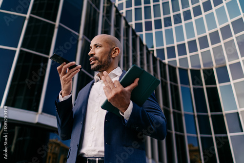 Photos Businessman talking with animated gesture, holding tablet, showcasing persuasive communication and confident mobile presence powered by multitasking tech fluency