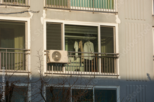 Apartment Balcony Window With Air Conditioner Outdoor Unit and Hanging Laundry Inside