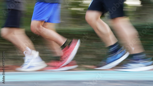 Group of runners in motion blur on a red running path, showcasing the intensity and power of a track meet