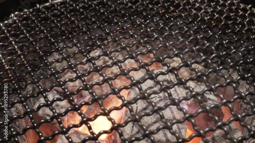 Cooking with charcoal on a grill at night in a backyard with friends sharing food and laughter