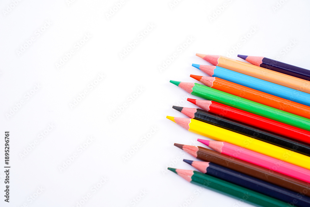 Fototapeta premium A vibrant collection of colored pencils arranged diagonally on a plain white background for art and design