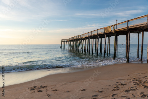 Ocean City, Maryland, USA - 26 June 2014 - Photo showing a wooden pier with light waves and a sandy beach in Ocean City, Maryland.