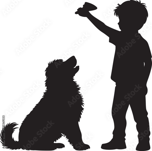 A young boy holding up a small toy for his fluffy sitting dog on a clean white background