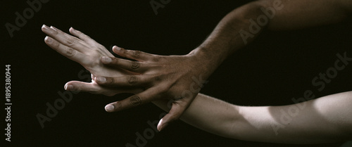This image captures two hands locked in a firm grasp, representing themes of unity and deep emotional connection, surrounded by an aura of artistry and contrasting shadow.