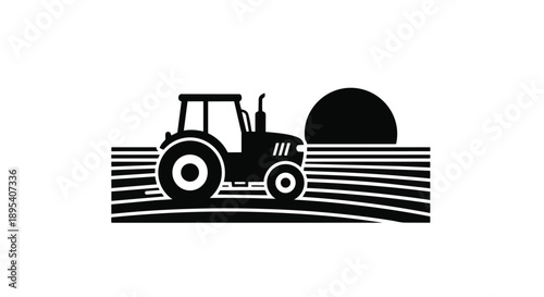 Black silhouette of a tractor on a field at sunset