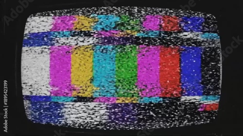 Screen shows static noise with no clear image or sound during late night broadcast interruption in urban setting