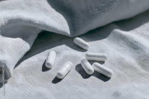 White capsules arranged on a light cloth at a close distance during daylight