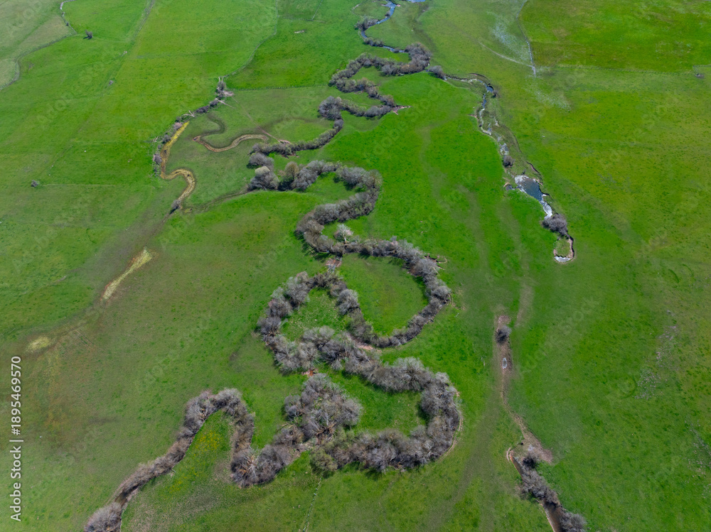 Obraz premium Aerial view from a drone of the meanders of the Izarilla River in the municipality of Campoo de Suso in the Campoo-Los Valles region. Cantabria. Spain. Europe