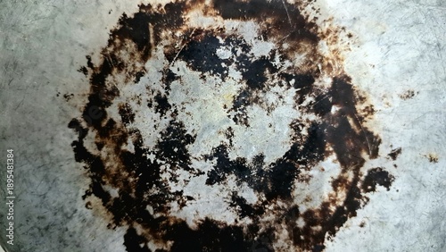 фотографія Macro view of a burnt metal pan bottom with scorched circular marks, industrial grunge texture background for abstract graphic design, vintage kitchenware surface detail, and weathering concept