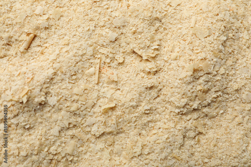 Naklejka premium Dry yeast flakes as background, top view