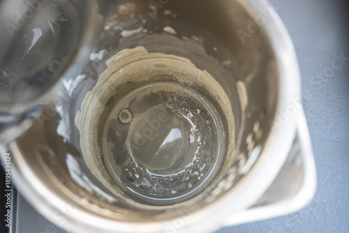 Electric kettle with stone limescale. Metal teapot in the kitchen.