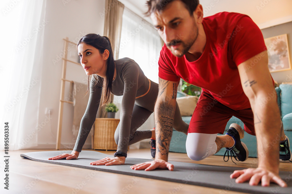 Fototapeta premium Couple doing cardio workout together at home