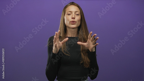 Foto Woman with hands gesturing, fingers splayed and eyes closed in purple studio, slight smile and ring on finger; calm mindfulness
