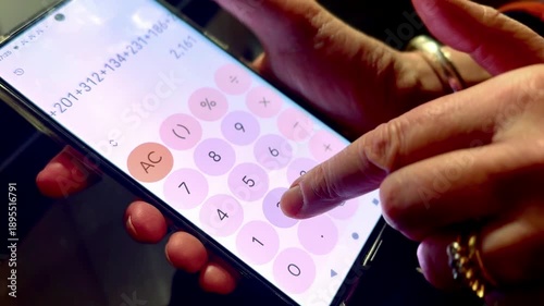 person doing math addition adding up numbers on calculator app on smart phone