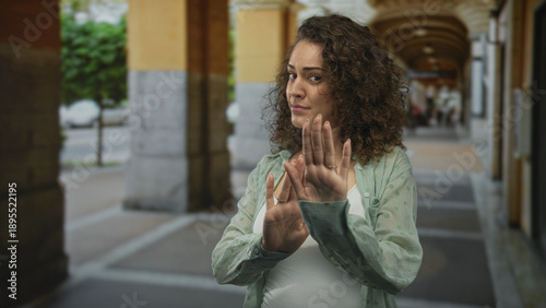 Tableau sur toile Woman with palms out showing hands in a defensive gesture on a street; hesitation personal boundary