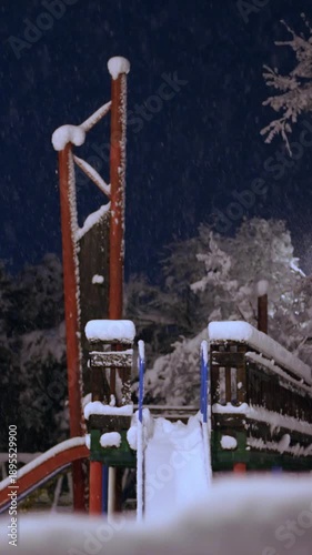 Children's playground covered in snow. Vertical shot. Night shot.
