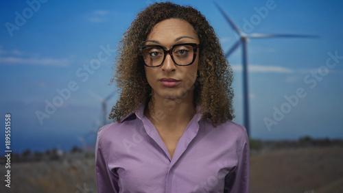 Slika na platnu Woman points index finger and thumb in l shape at windmill in forest; mockery sarcasm critique disdain