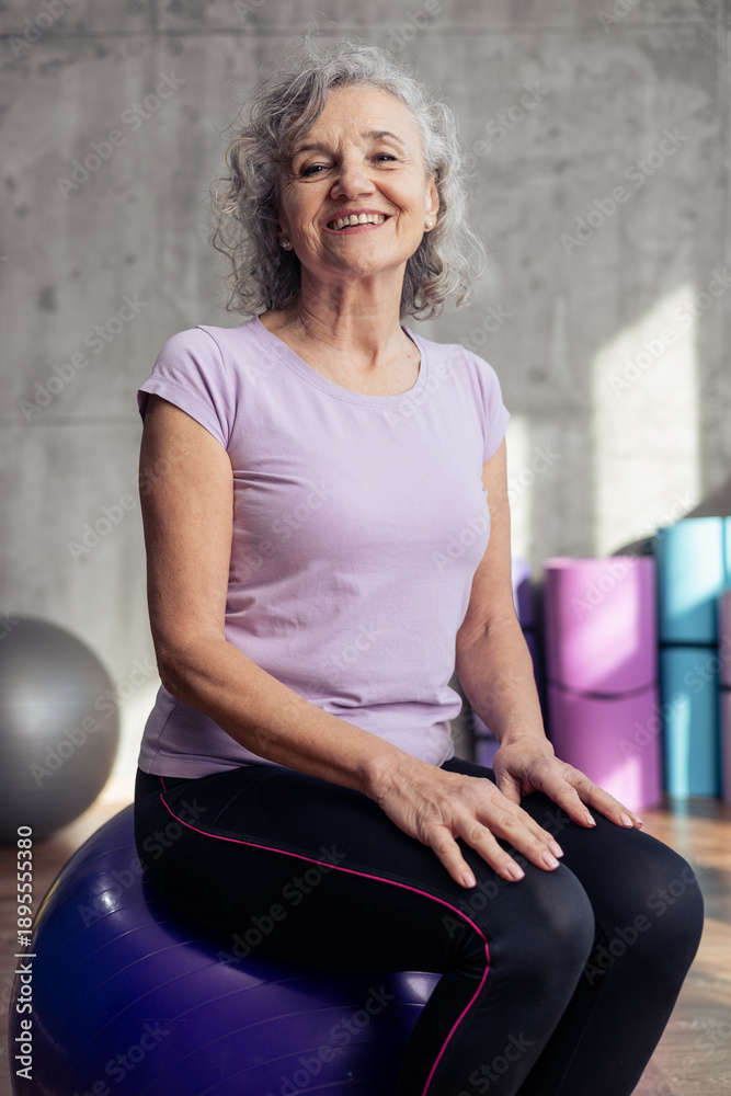Naklejka premium Senior woman smiling on fitness gym ball