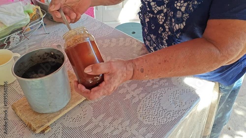 Woman sweetening traditional coffee with natural honey in a rustic kitchen setting