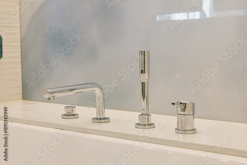 Tableau sur toile Faucet, sink and chrome bathroom fixtures arranged over a clean counter, water t