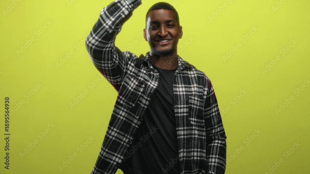 Fototapeta premium Man covers mouth with hand in studio against lime green backdrop, wearing a plaid flannel shirt and t shirt; playful confidence.