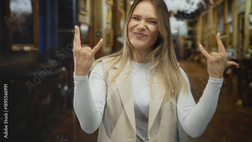 Slika na platnu Woman gesturing rock sign indoors with playful expression in a church setting, showcasing vibrant emotion and personality