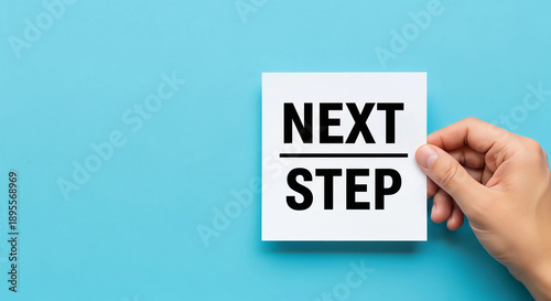 Hand holding card with next step message on blue background
