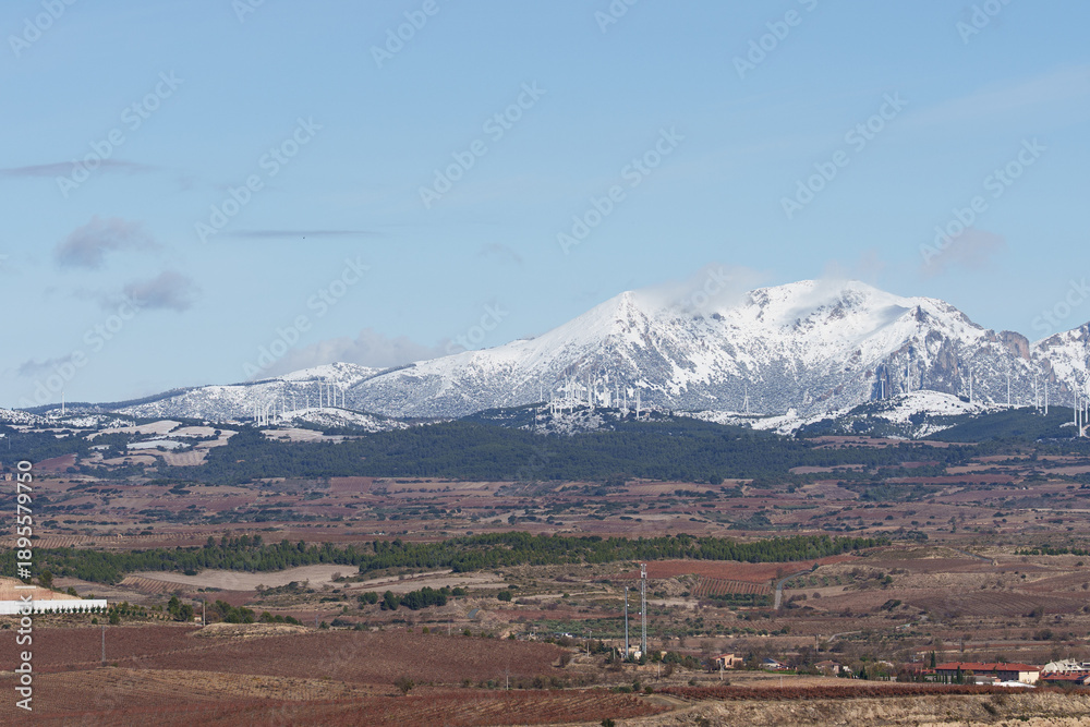 Fototapeta premium Snow-Capped Mountains and Wind Turbines Near Logrono, Spain